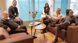 Four men and one woman is sitting on couches around a small table at the VIP airport terminal in Bergen